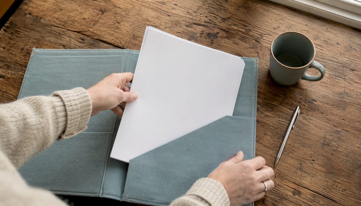 Hands placing insurance binder in folder