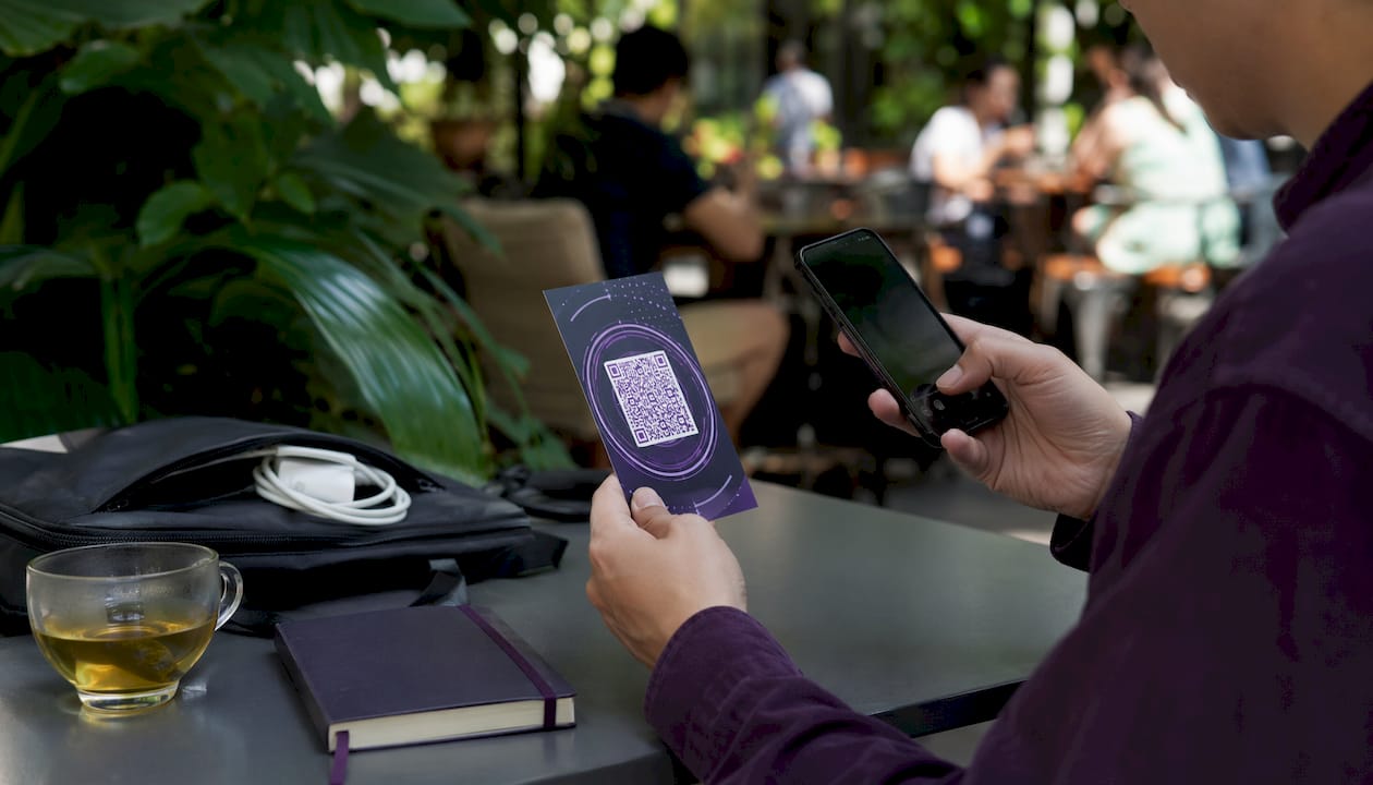 Hands scanning dynamic QR code with smartphone