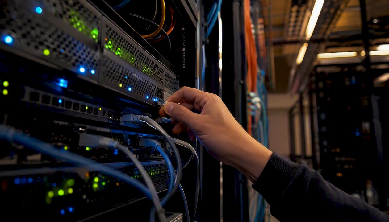 Technician's hand connecting network cable