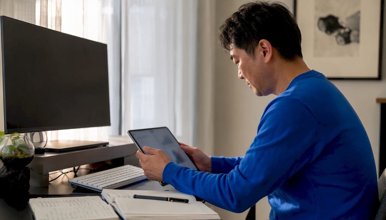 Man reviewing AI analytics on tablet in home office