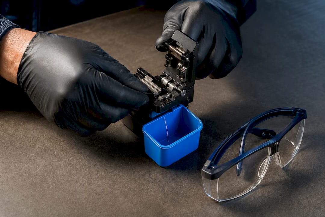 Technician cleaving fiber over collection cup