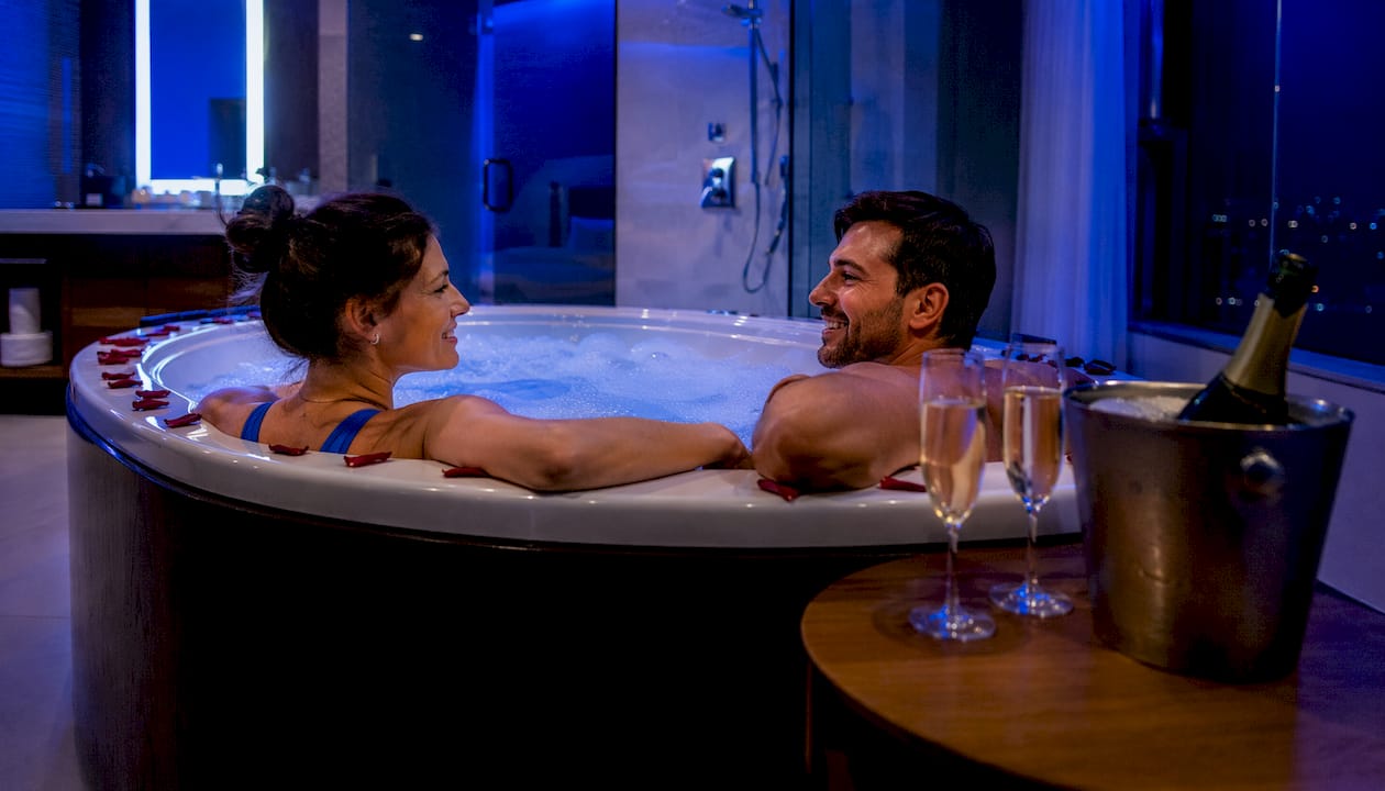 Romantic jacuzzi hotel room ambiance with rose petals