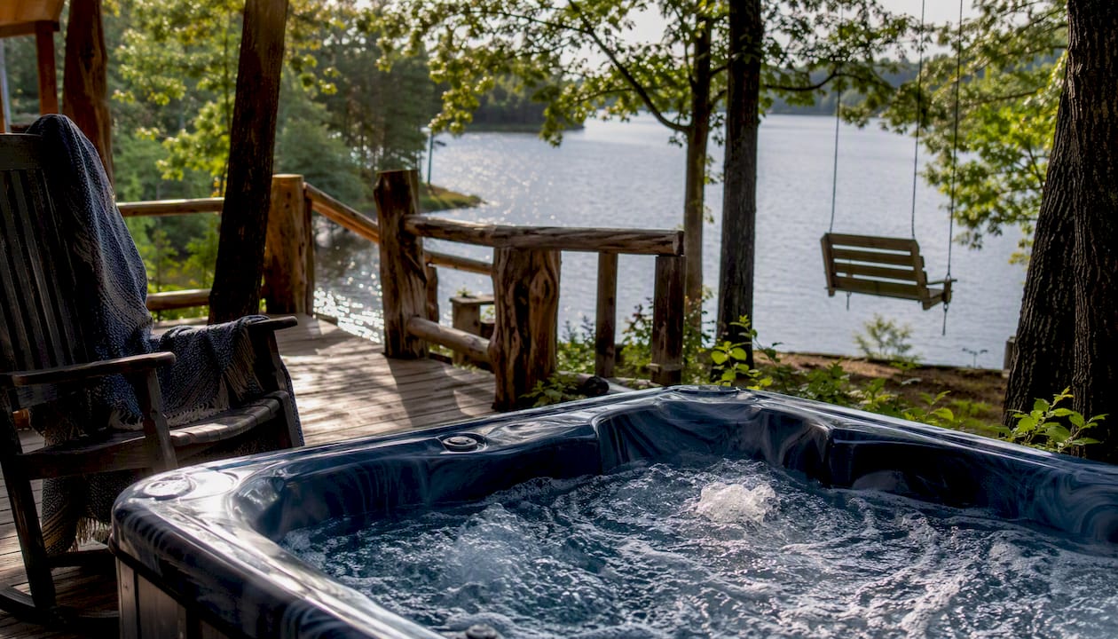 Private hot tub on rustic cabin deck in Ozarks daylight