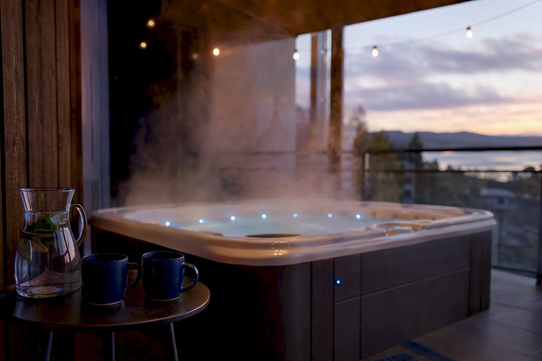 Private hotel balcony hot tub steaming at dusk
