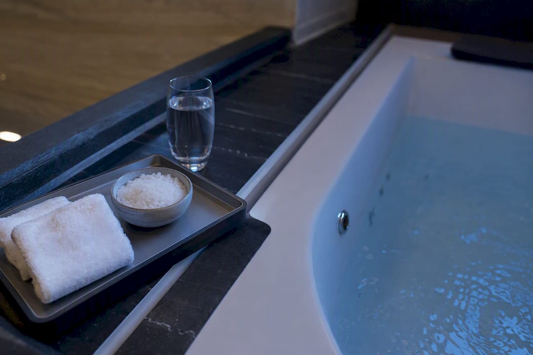 Hotel bathroom tray with spa salts and tub edge
