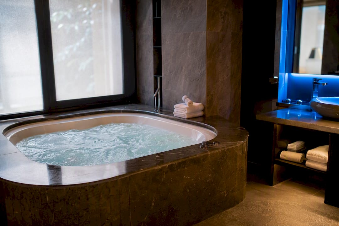 Private jacuzzi bubbling in hotel suite bathroom