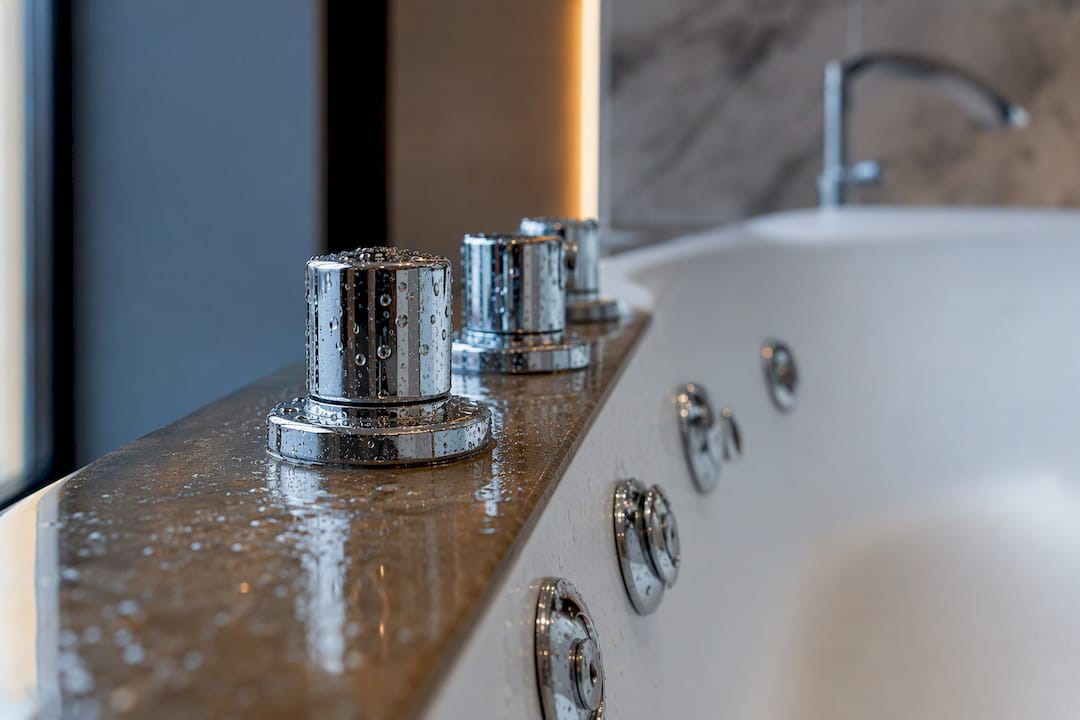 Close-up jacuzzi tub jets and faucet in hotel bathroom
