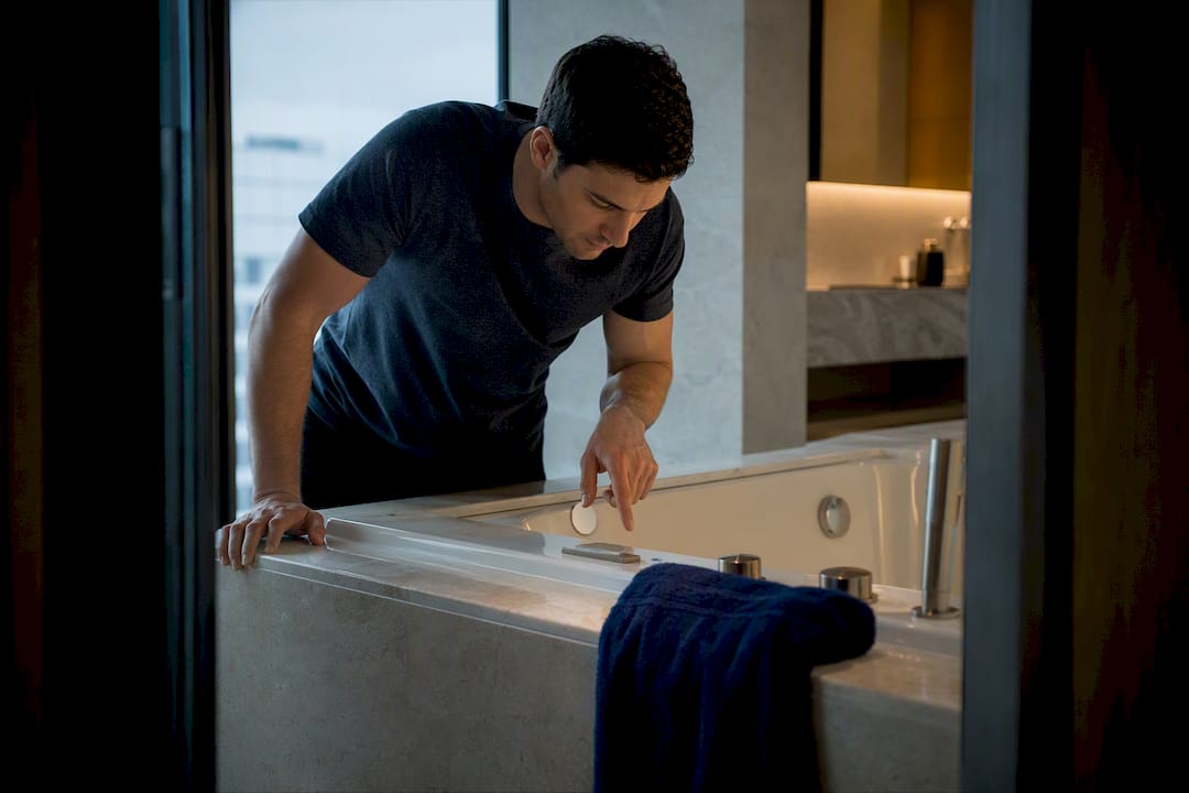 Guest inspecting an in-room spa tub