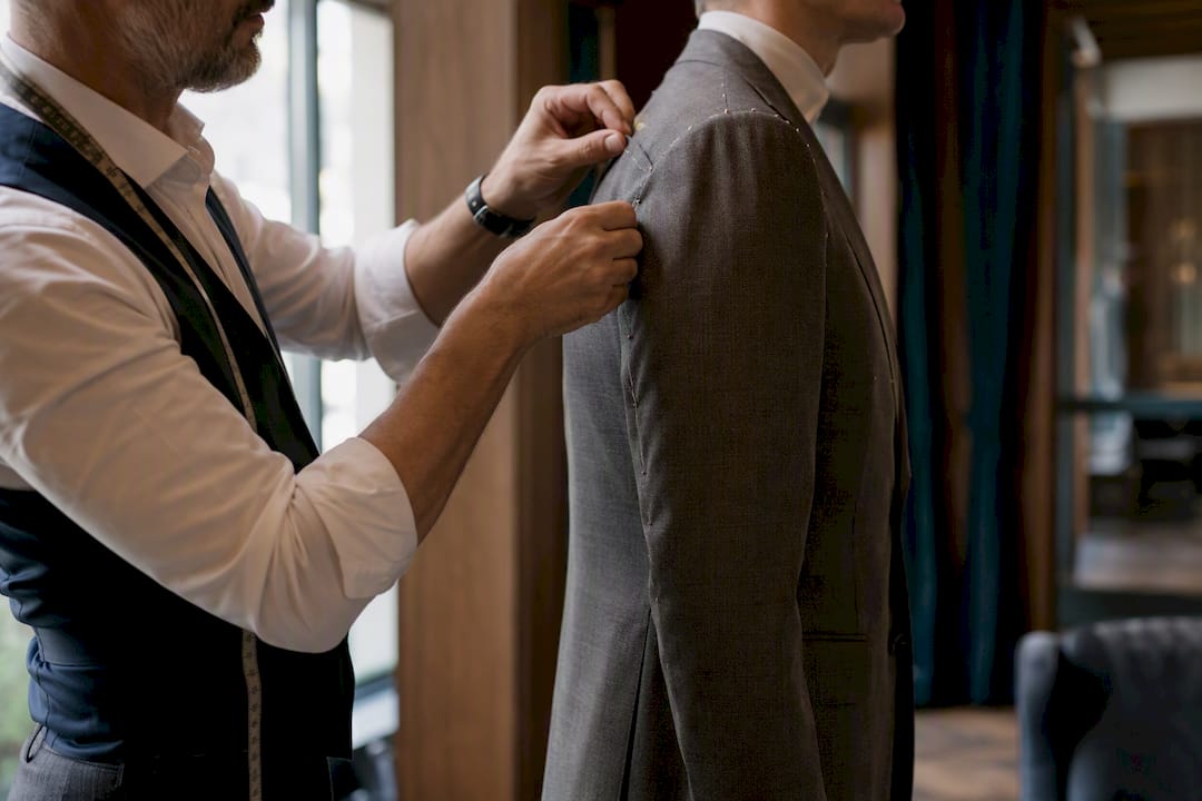 Tailor adjusting shoulder darts on soft shoulder jacket