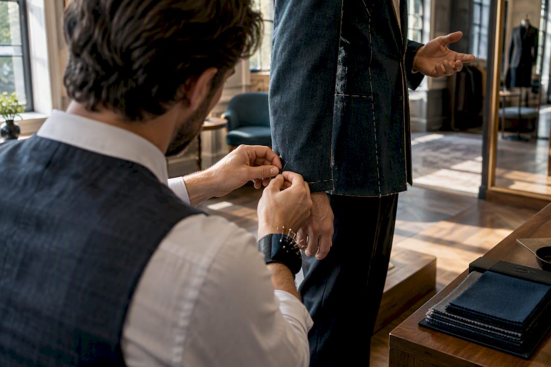 Tailor pinning sleeve during fitting appointment