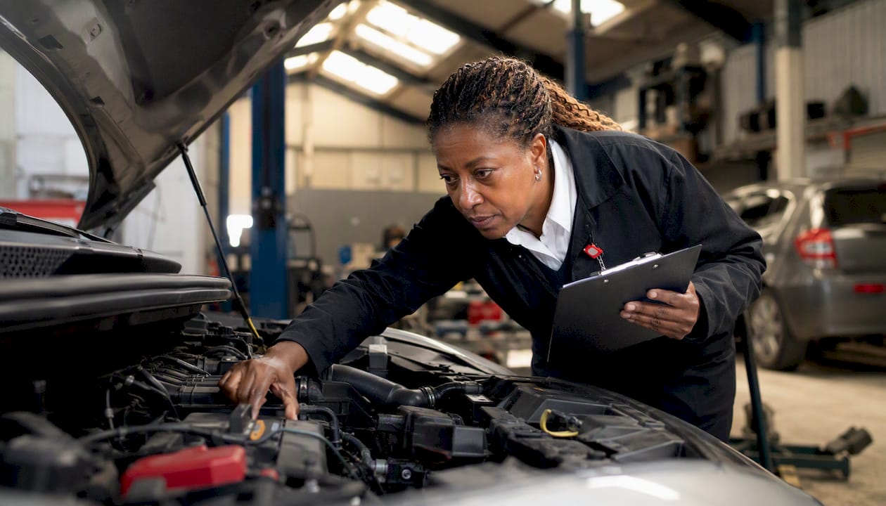 Inspector checking car engine at MOT centre