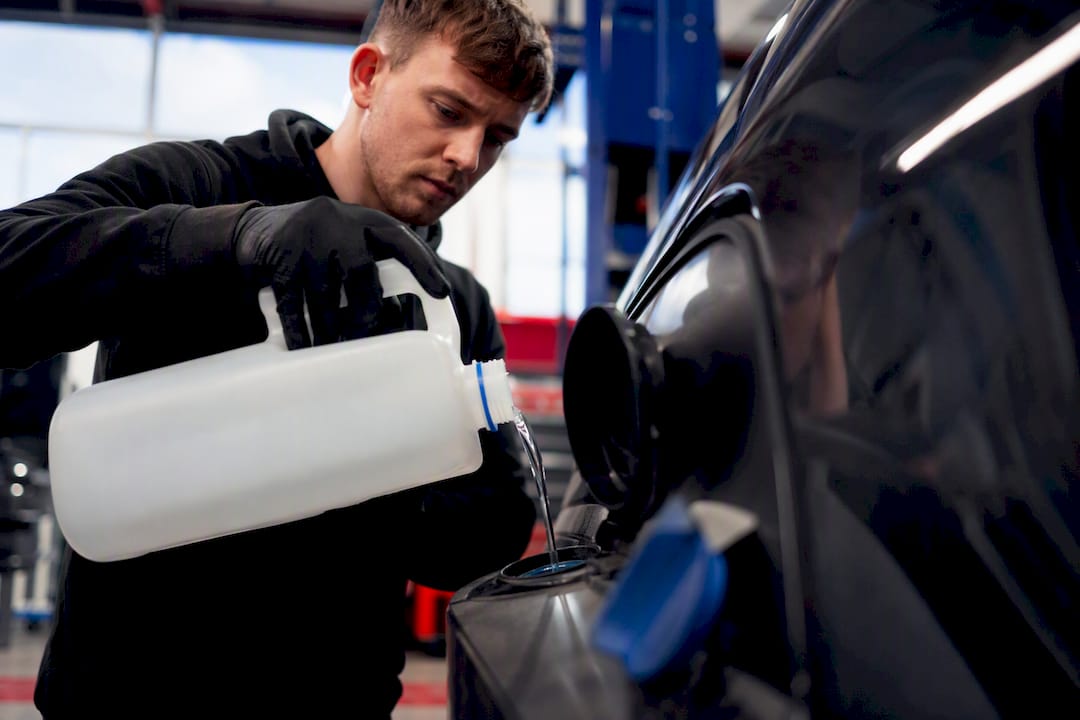 Hands pouring AdBlue fluid into tank