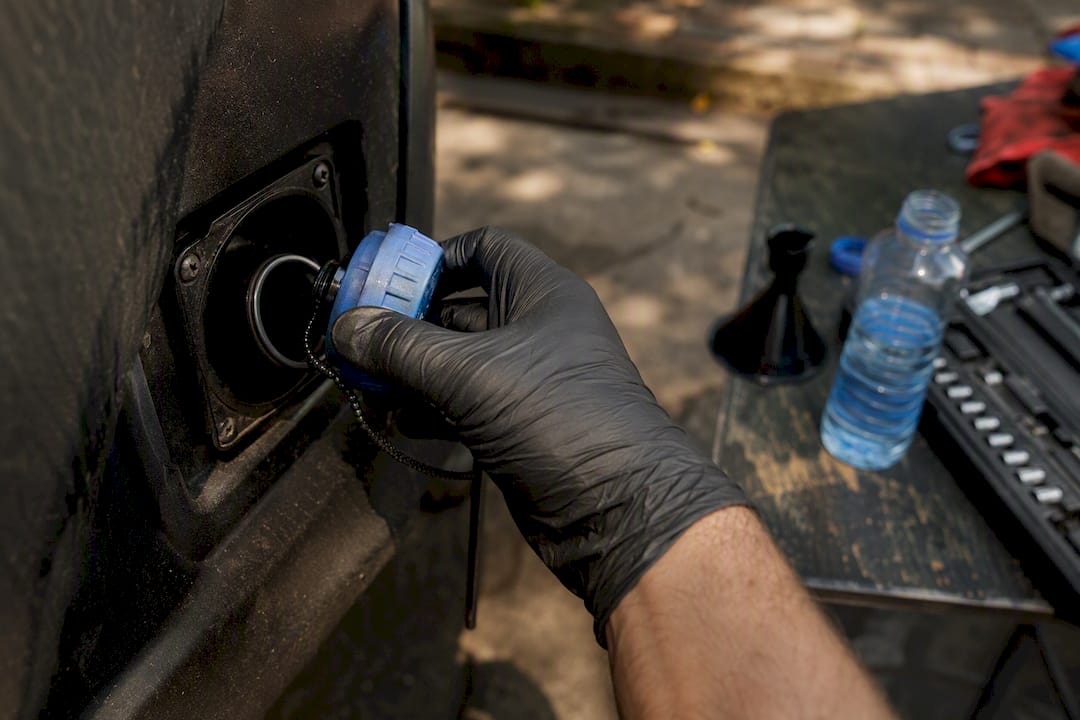 Hands opening AdBlue filler cap