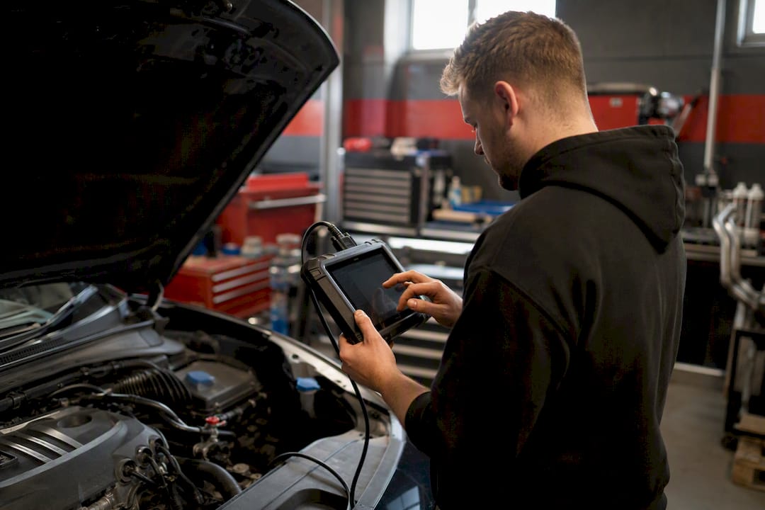 Technician connecting diagnostic scanner to car engine