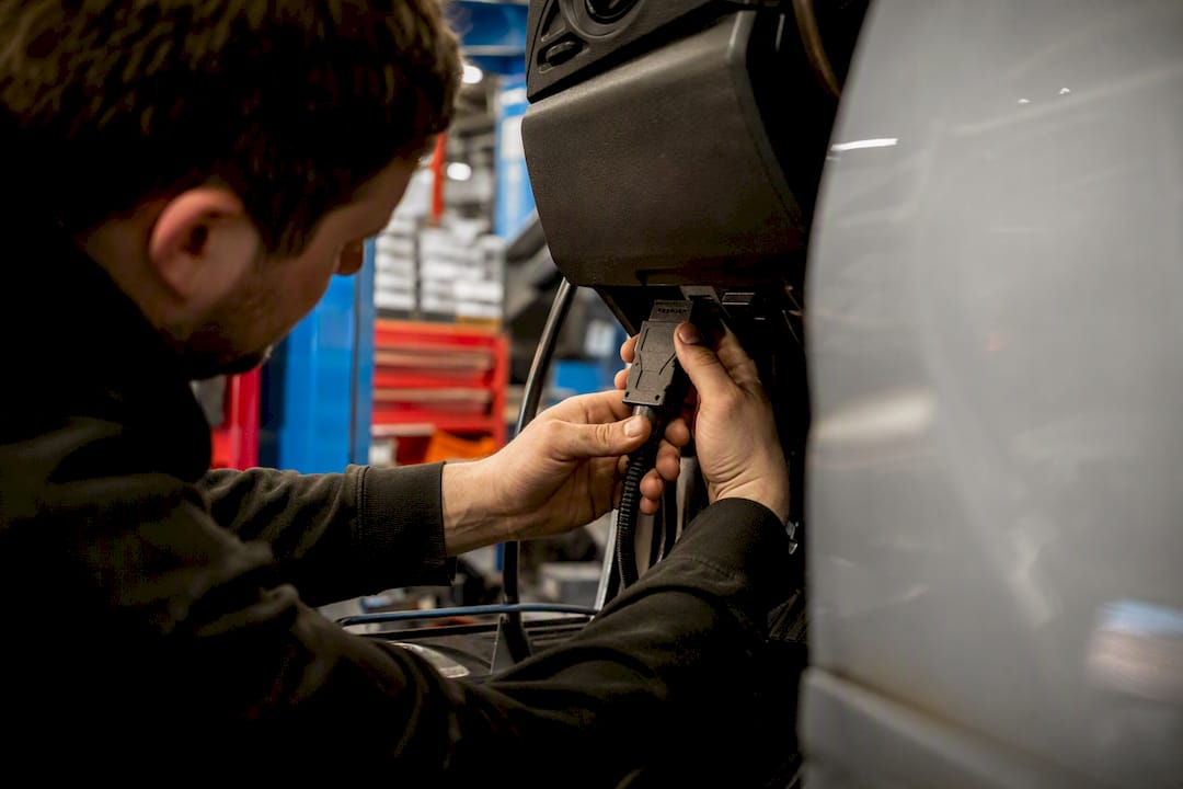 Hands connecting tuning tool to car ECU