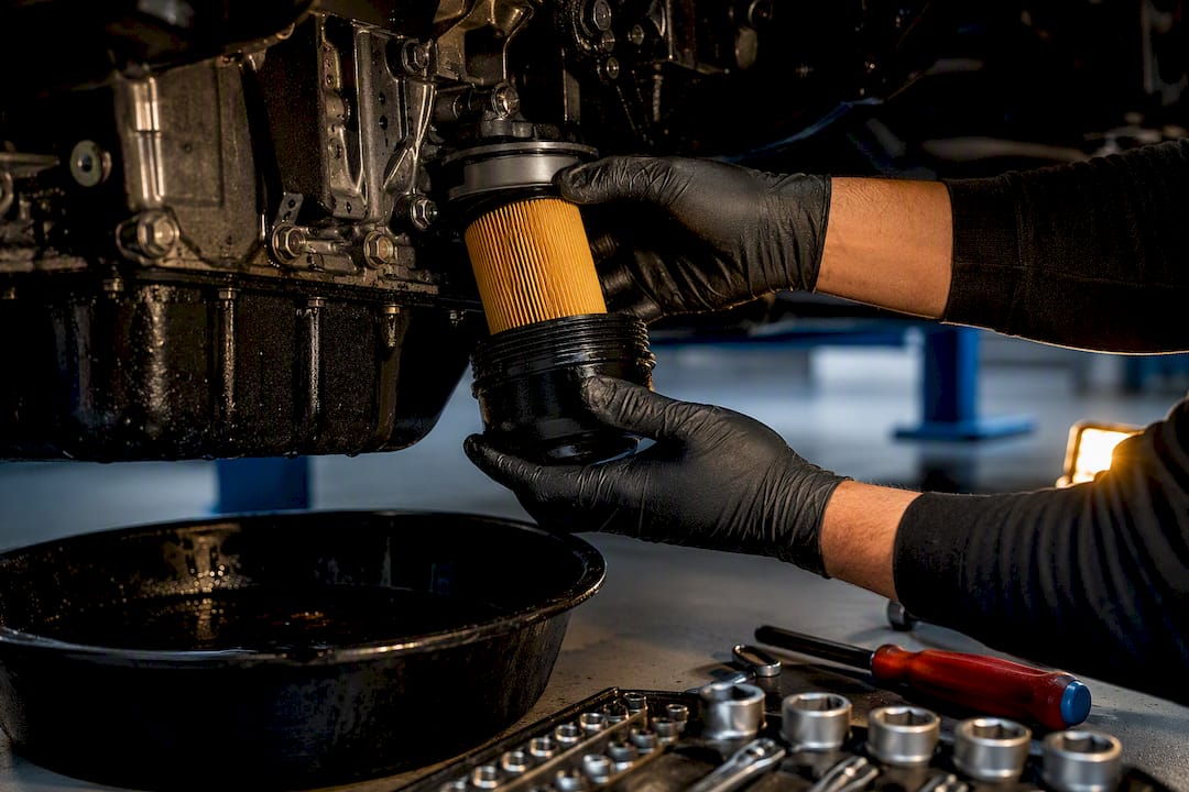 Technician replacing diesel engine oil filter