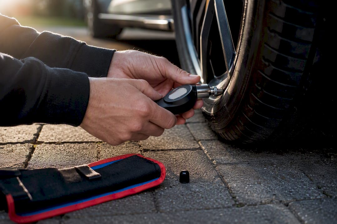Driver checking tyre pressure before driving