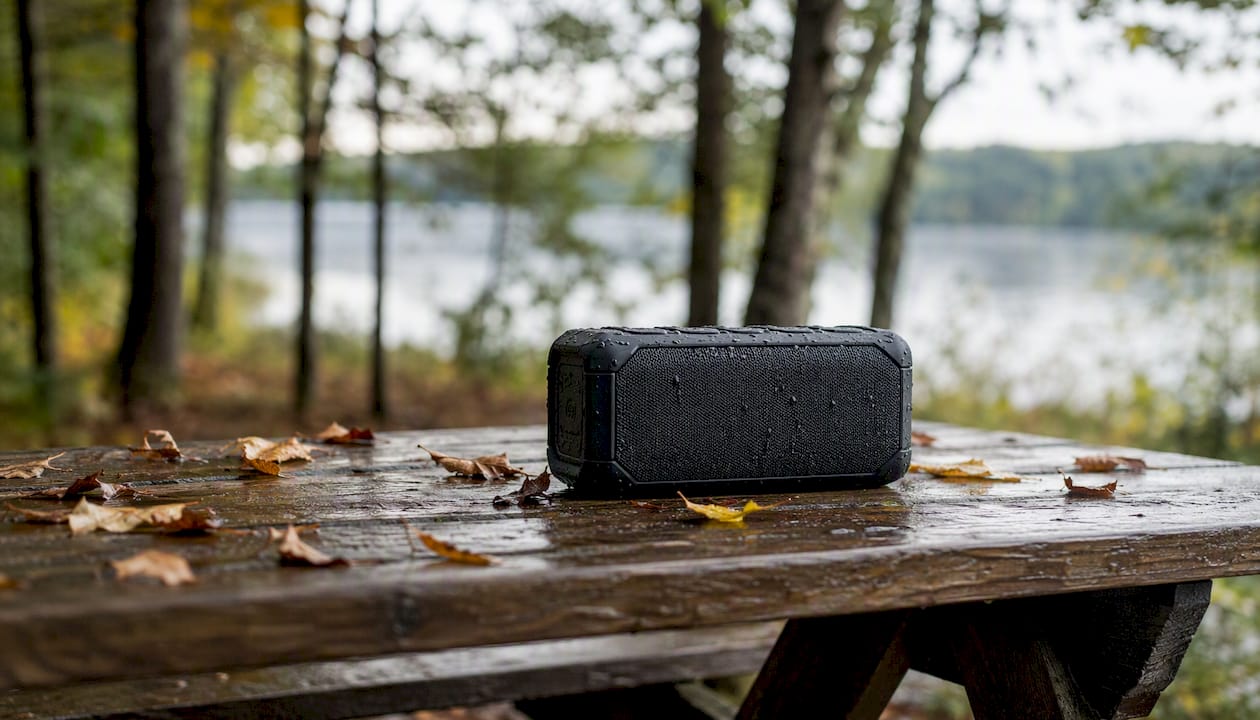Rugged portable speaker outdoors with water droplets