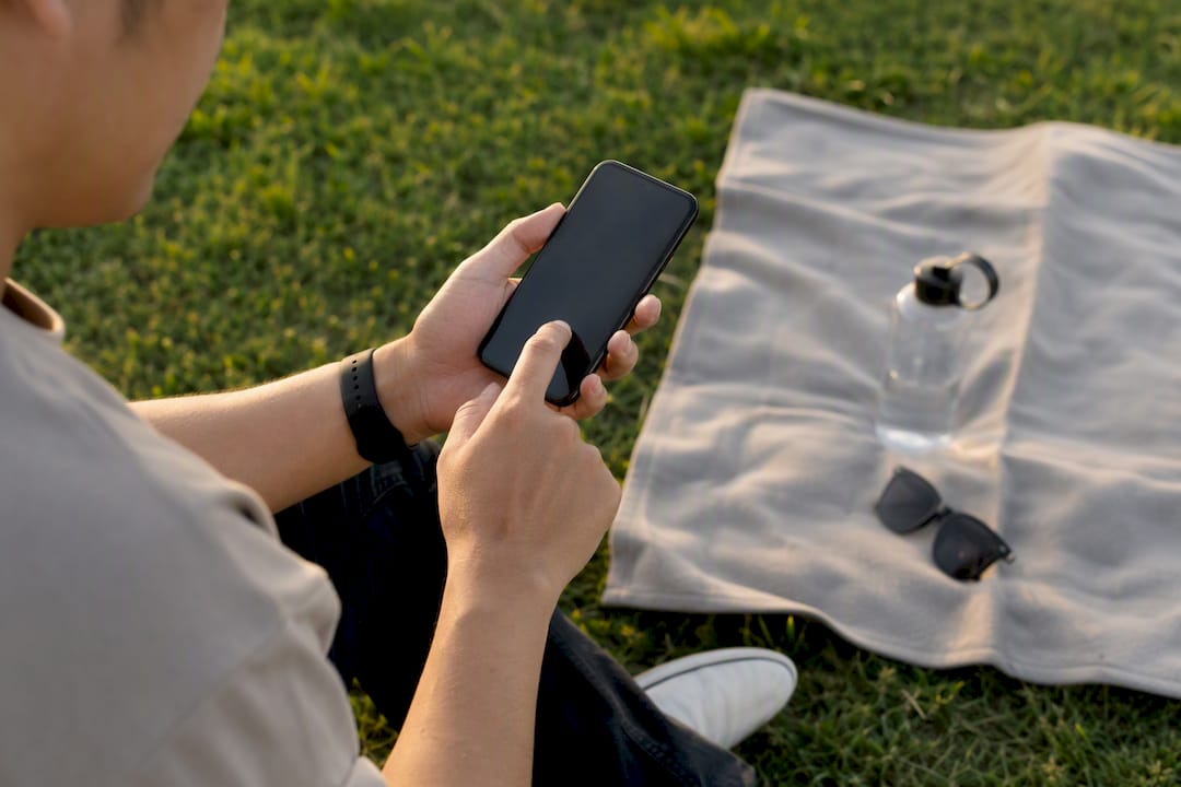Hands managing podcast downloads on smartphone
