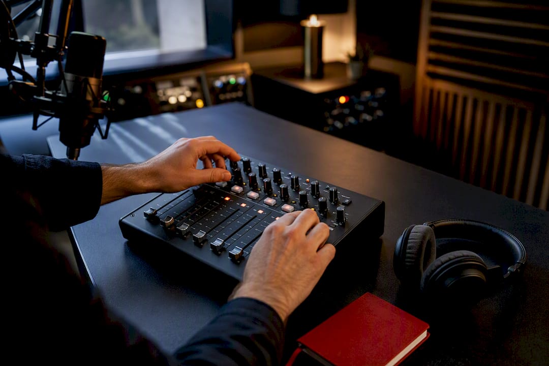 Podcast producer adjusting an audio mixer