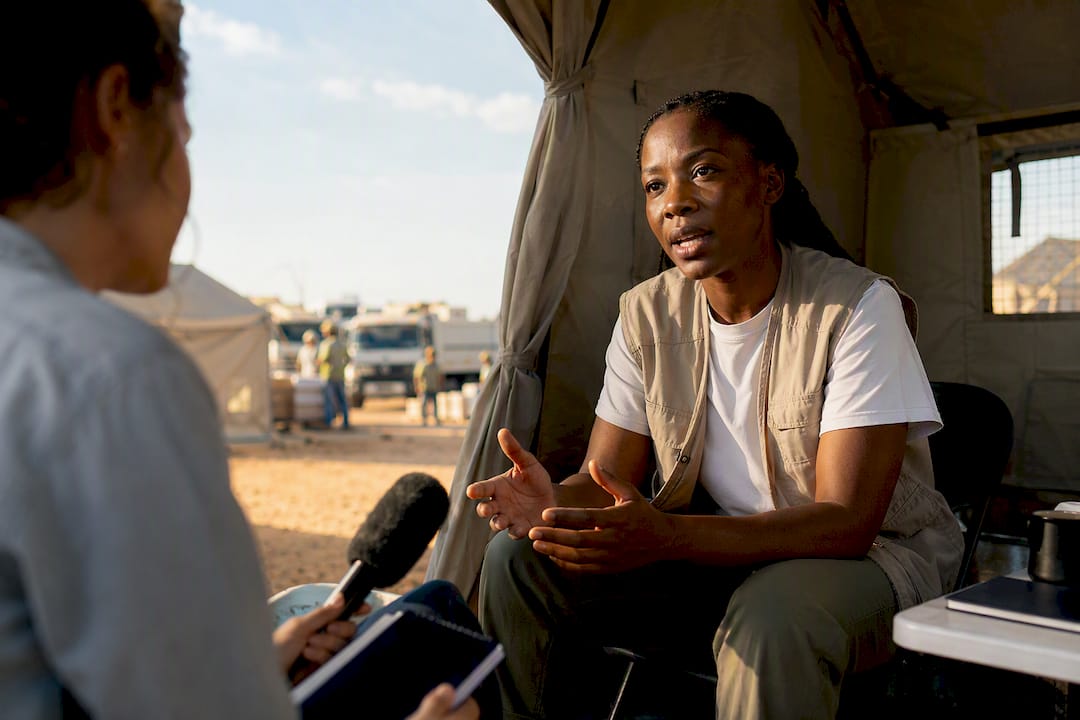 Reporter interviewing aid worker in field