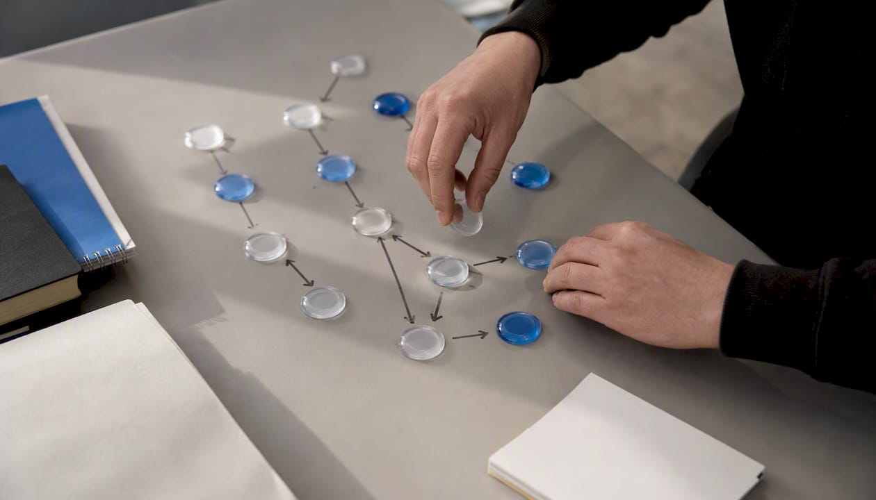 Hands arranging workflow tokens to map process