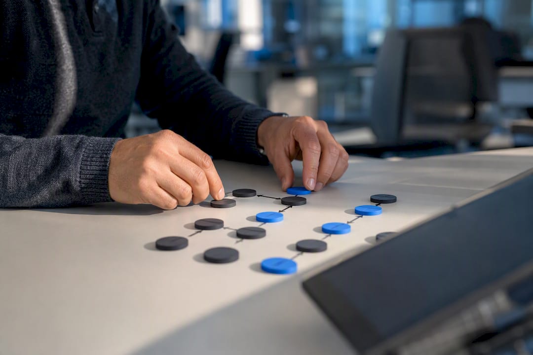 Hands sorting workflow tokens on technology desk
