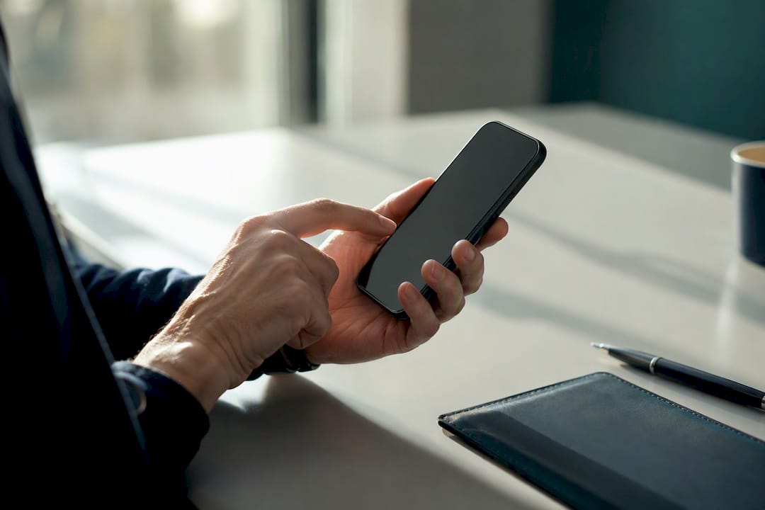 Dłonie trzymające smartfon z czarnym ekranem