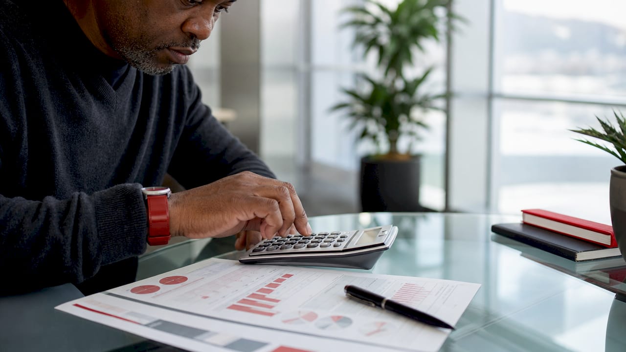 Close-up of hands calculating ROAS with reports