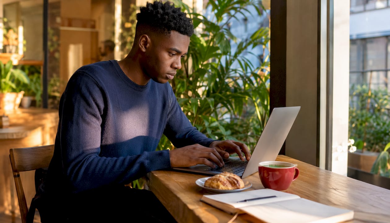 Hands typing laptop in home office