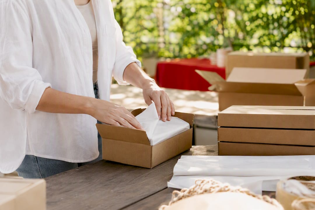 Hands packing product boxes