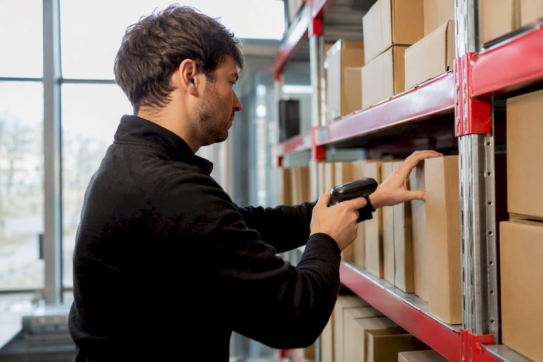 Hands adjusting inventory labels in warehouse