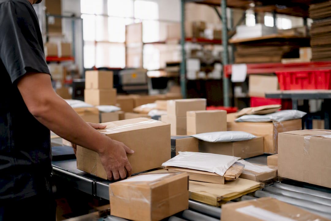 Hands sorting different packages in warehouse