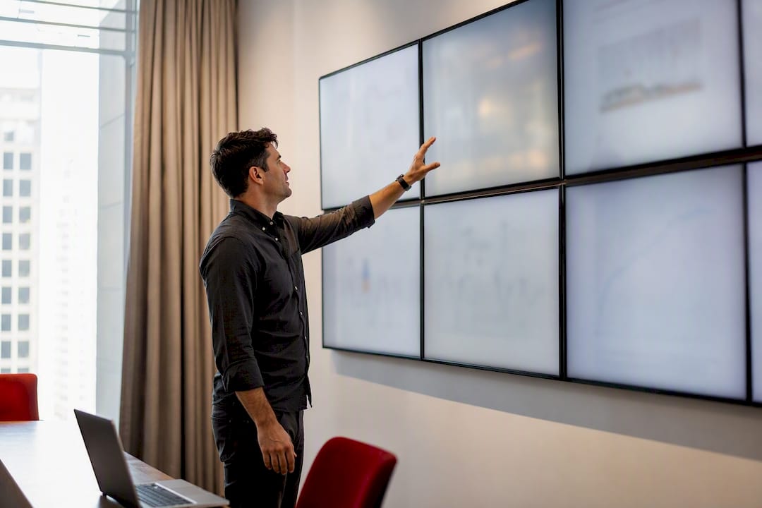 Silhouette pointing at digital data screens