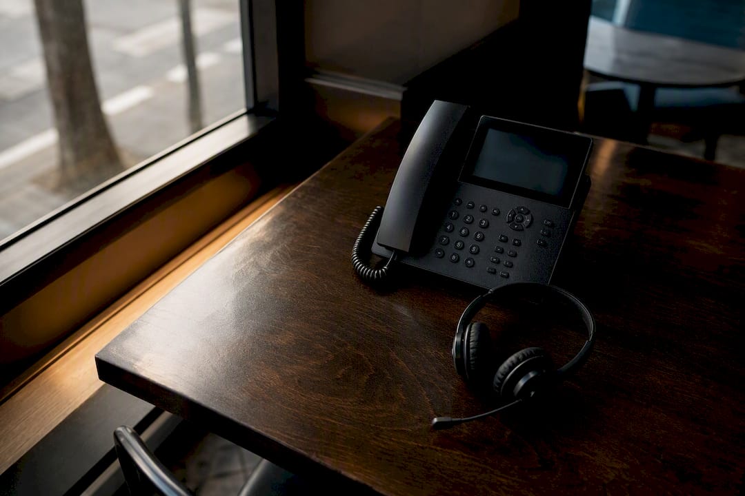 Unused business phone with headset on table