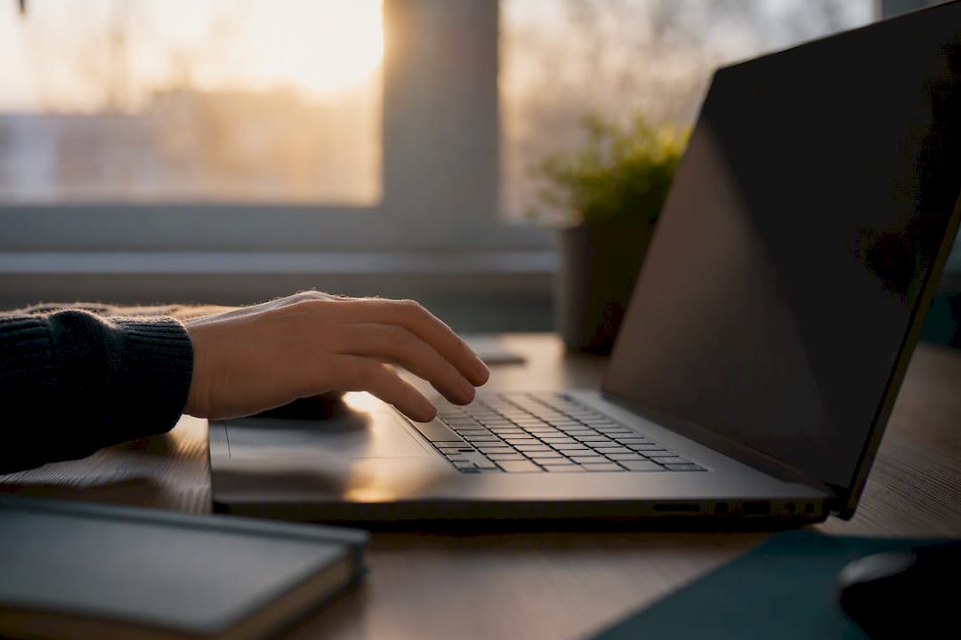 Person about to type on laptop with dark screen