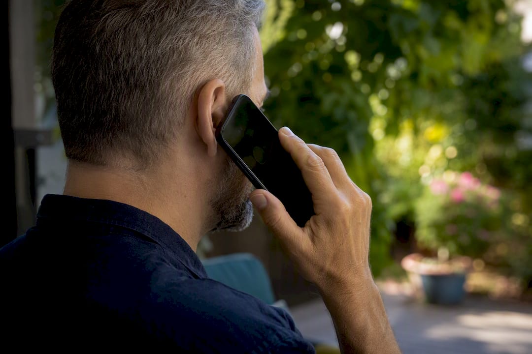 Hand holding phone with spoofed call alert