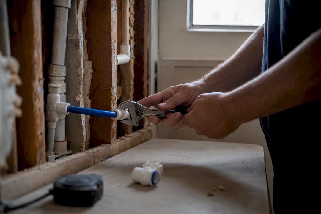 Hands tightening refrigerator water line fitting