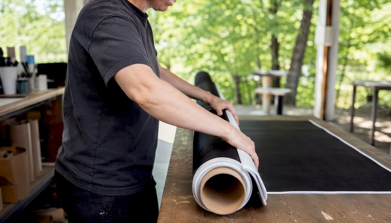 Hands rolling vinyl banner onto core