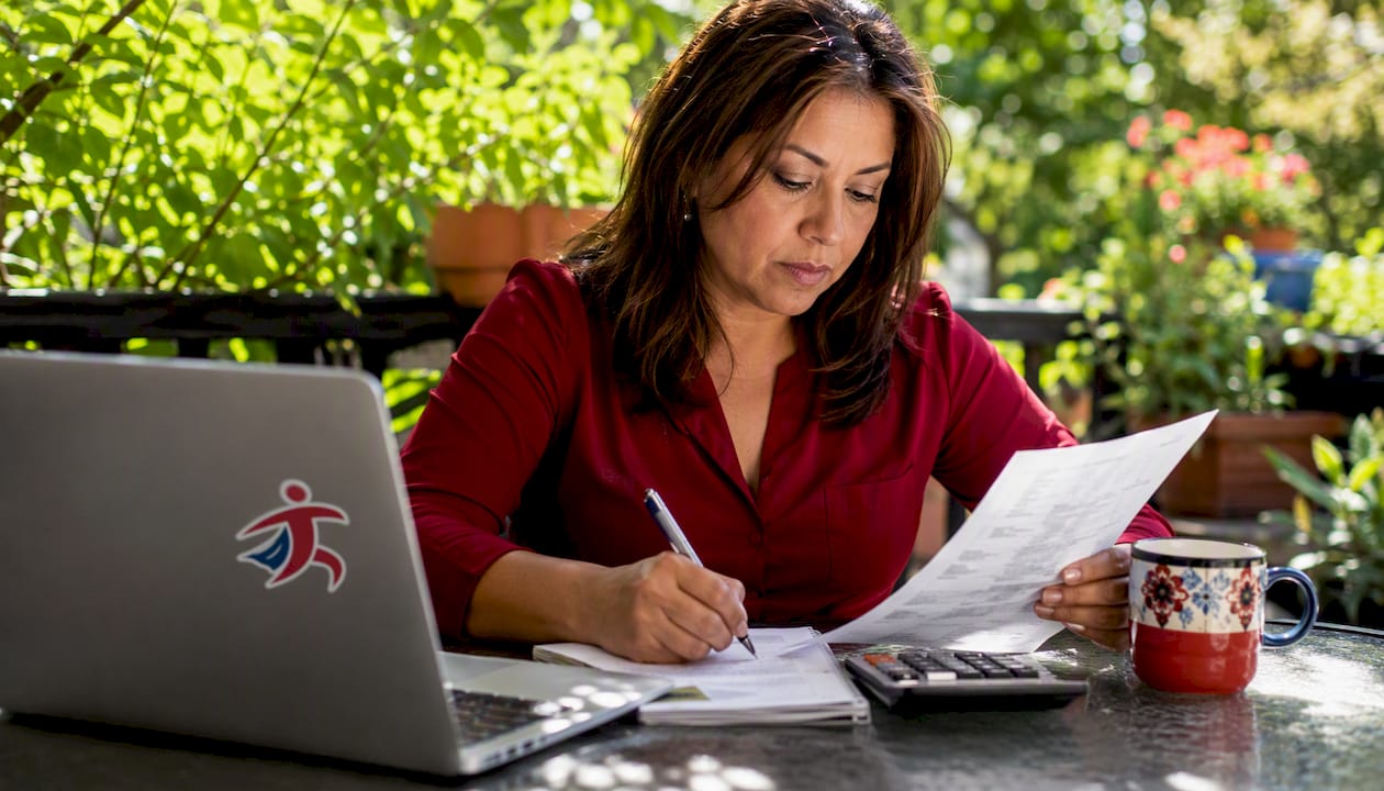 Woman reviewing 1099 form documents at home desk