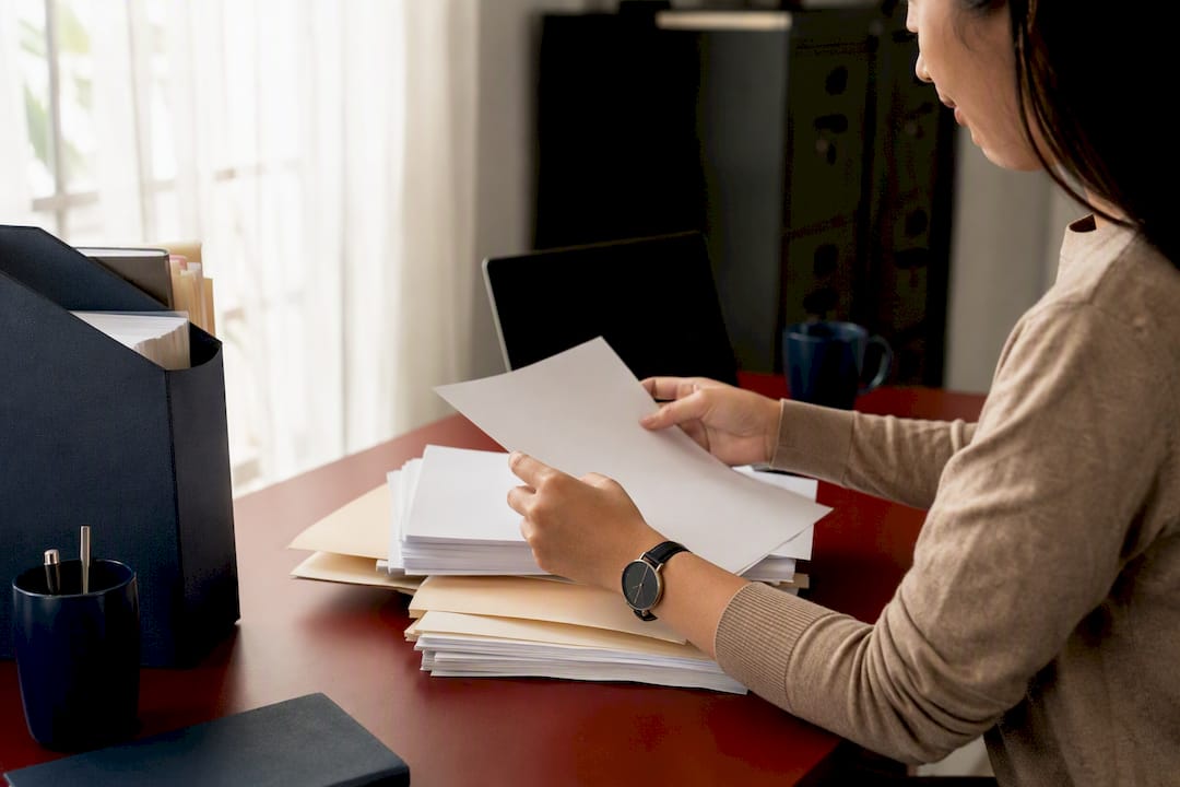 Hands arranging blank IRS tax forms on desk