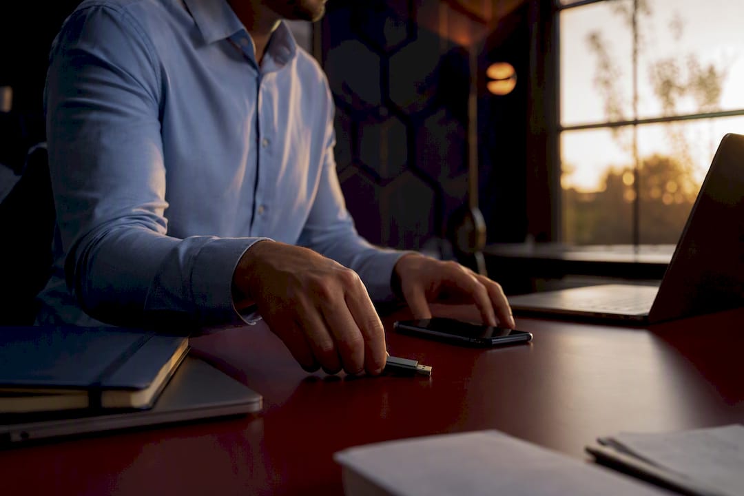 Hands placing security token and phone on desk