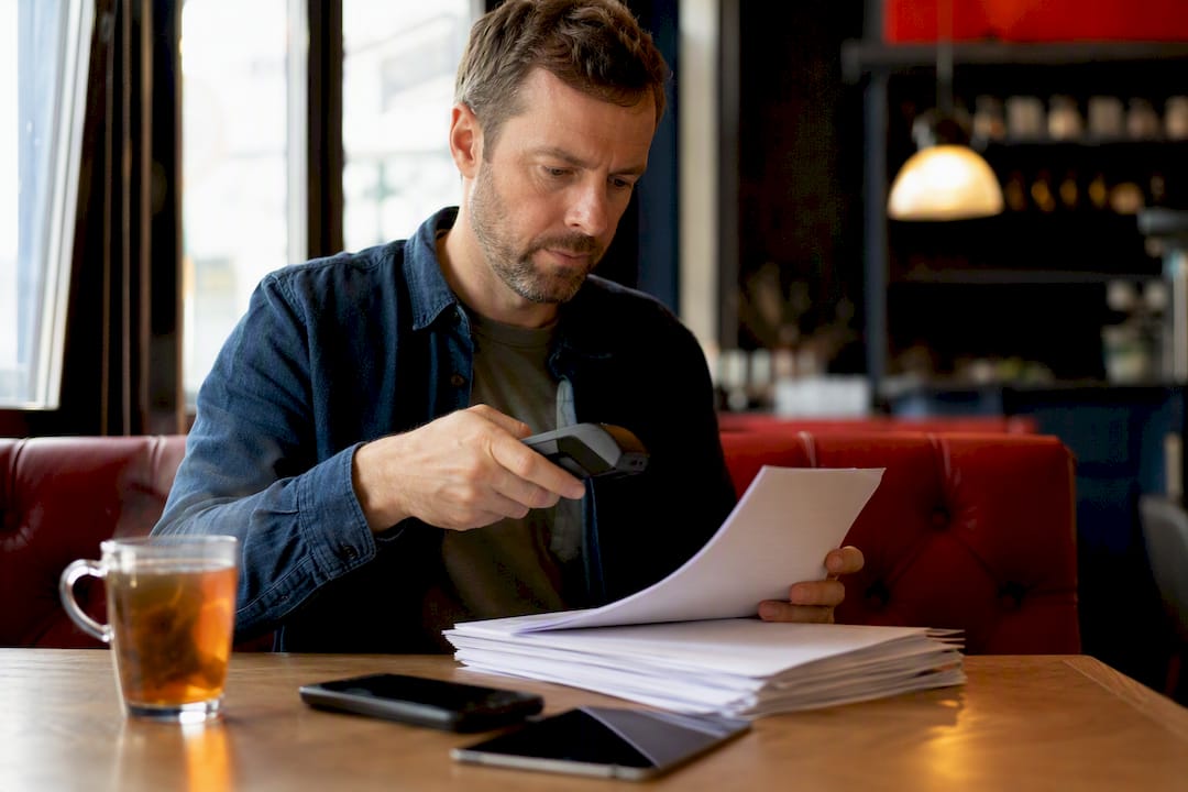 Person verifying tax documents at desk