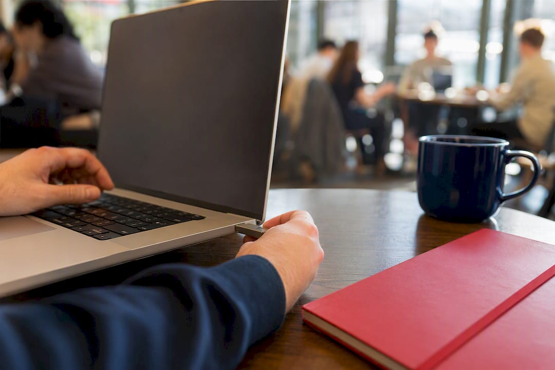 Hands inserting security token into laptop