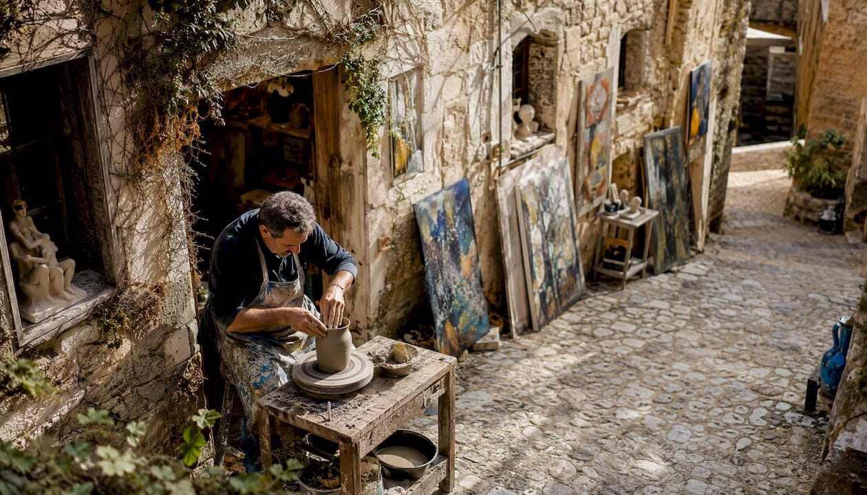 Un artista immerso nel suo lavoro, nel laboratorio che si affaccia su una caratteristica viuzza acciottolata.