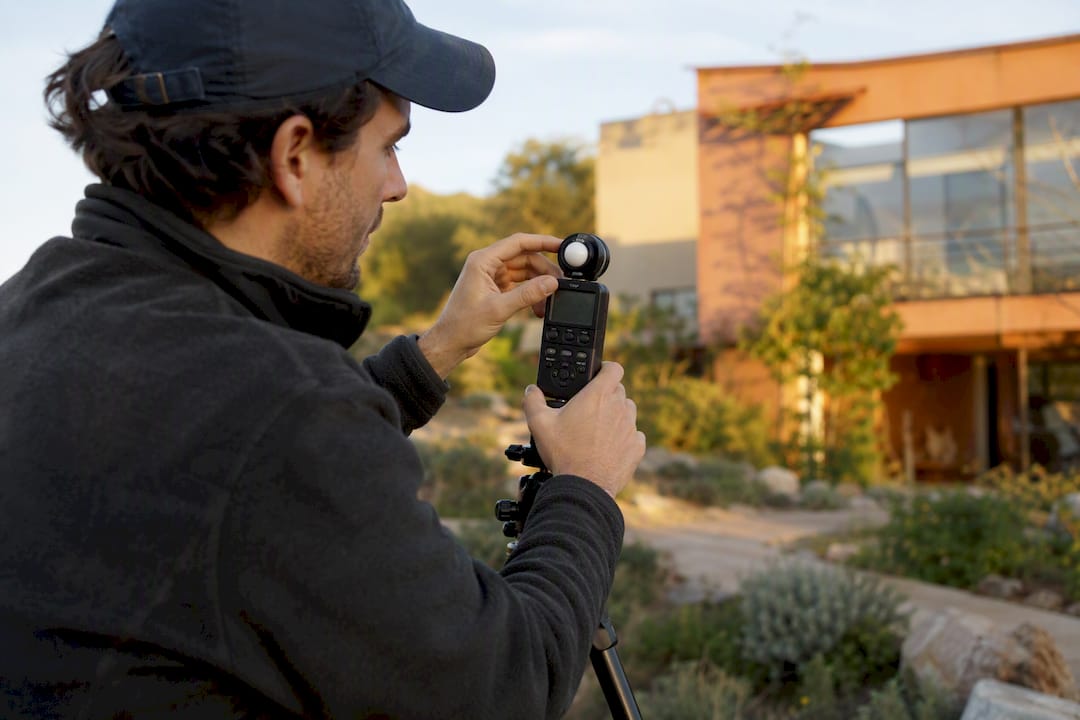 Technician adjusting daylight meter in residential garden