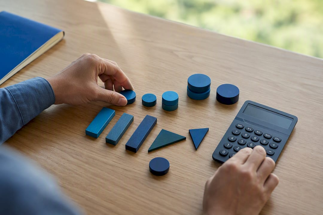 Hands with calculator and monetary tokens
