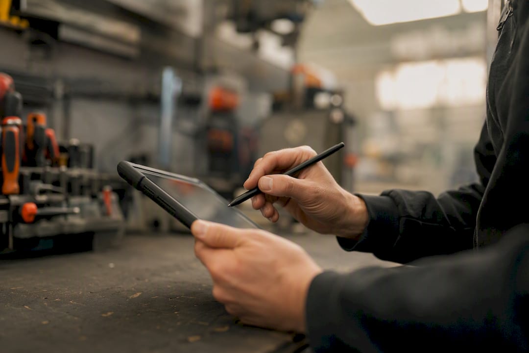 Mit dem Tablet werden technische Arbeiten in der Werkstatt erledigt.