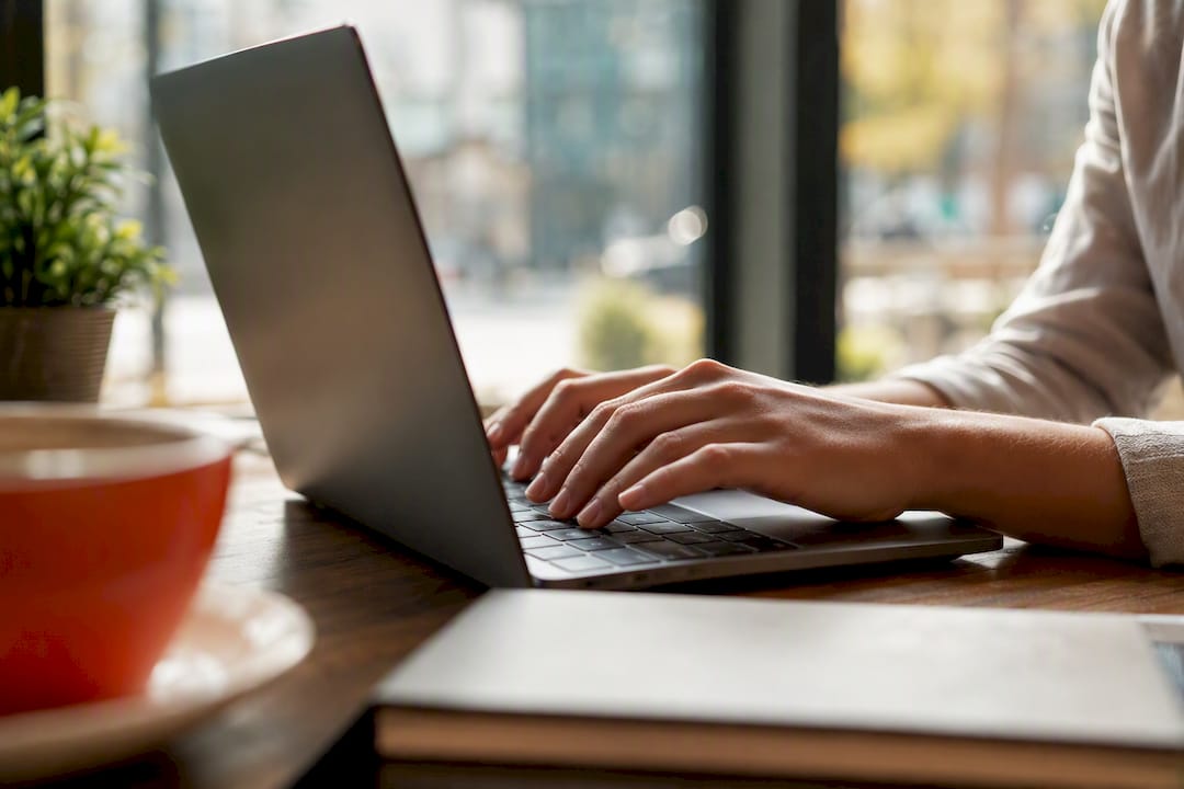Hände tippen am Computer bei der Jobsuche