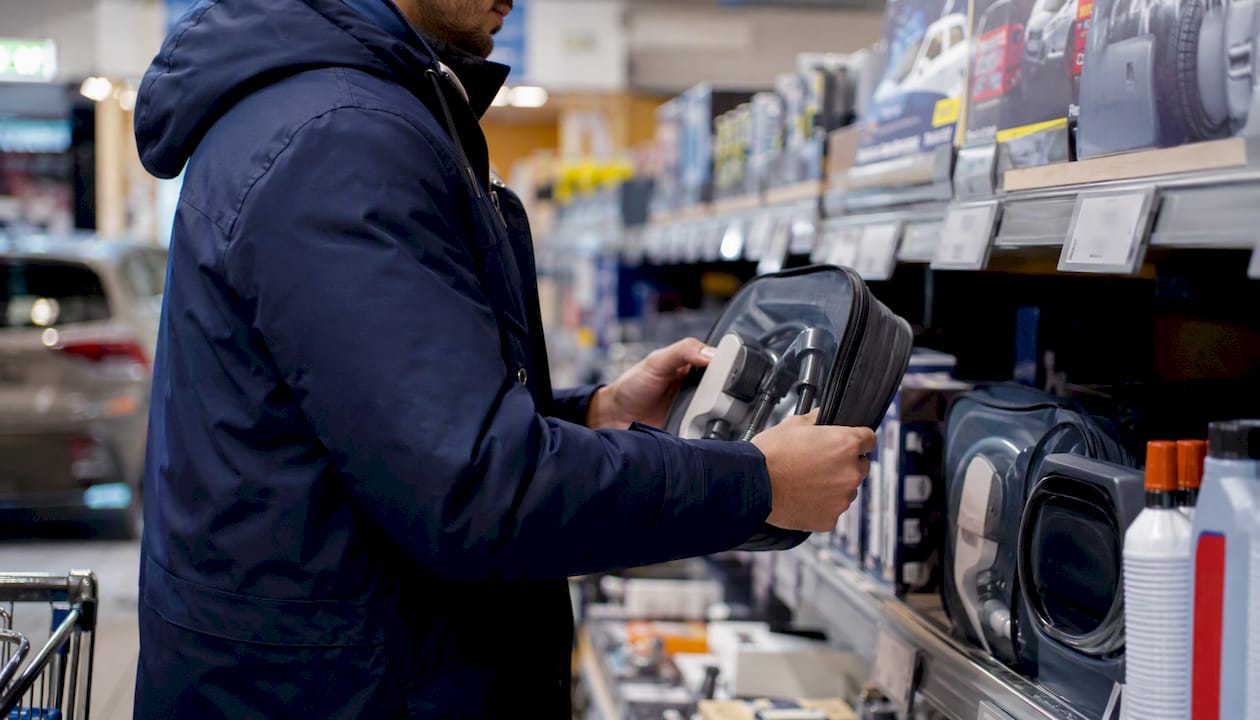 Mani che scelgono accessori per auto sugli scaffali di Lidl